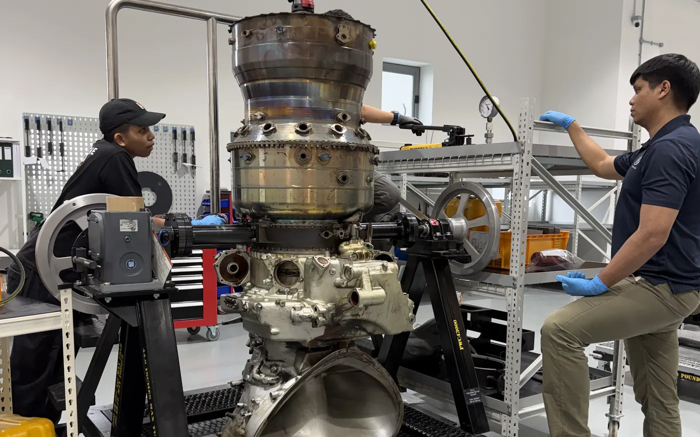 BIAero technicians working on an engine mounted upright on a teardown stand in Singapore