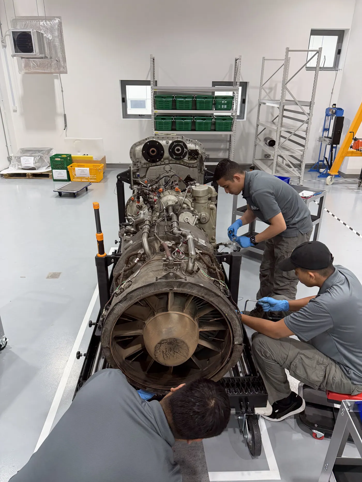 Technicians working on an engine on its stand during teardown